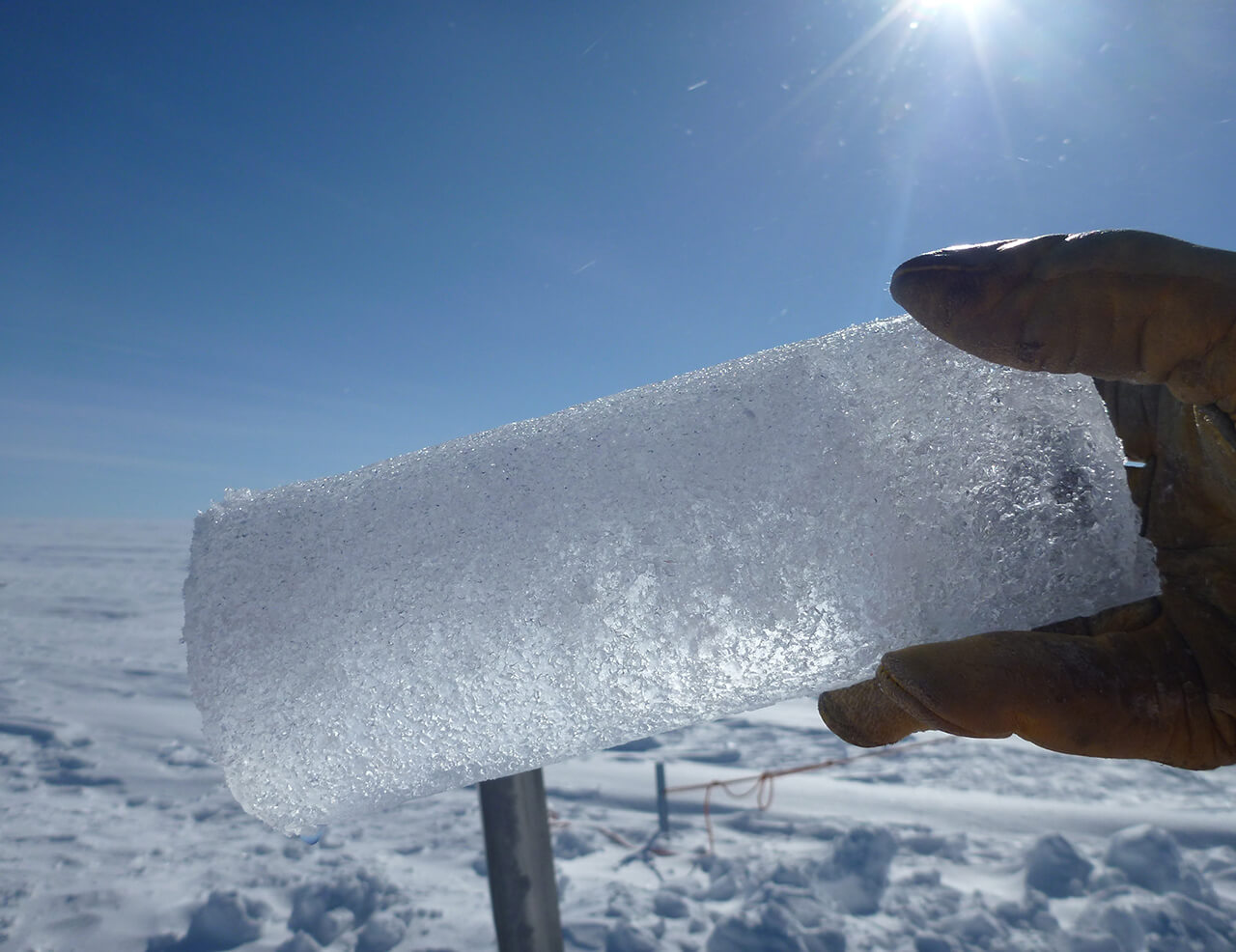 Photograph of a hand holding an ice core.